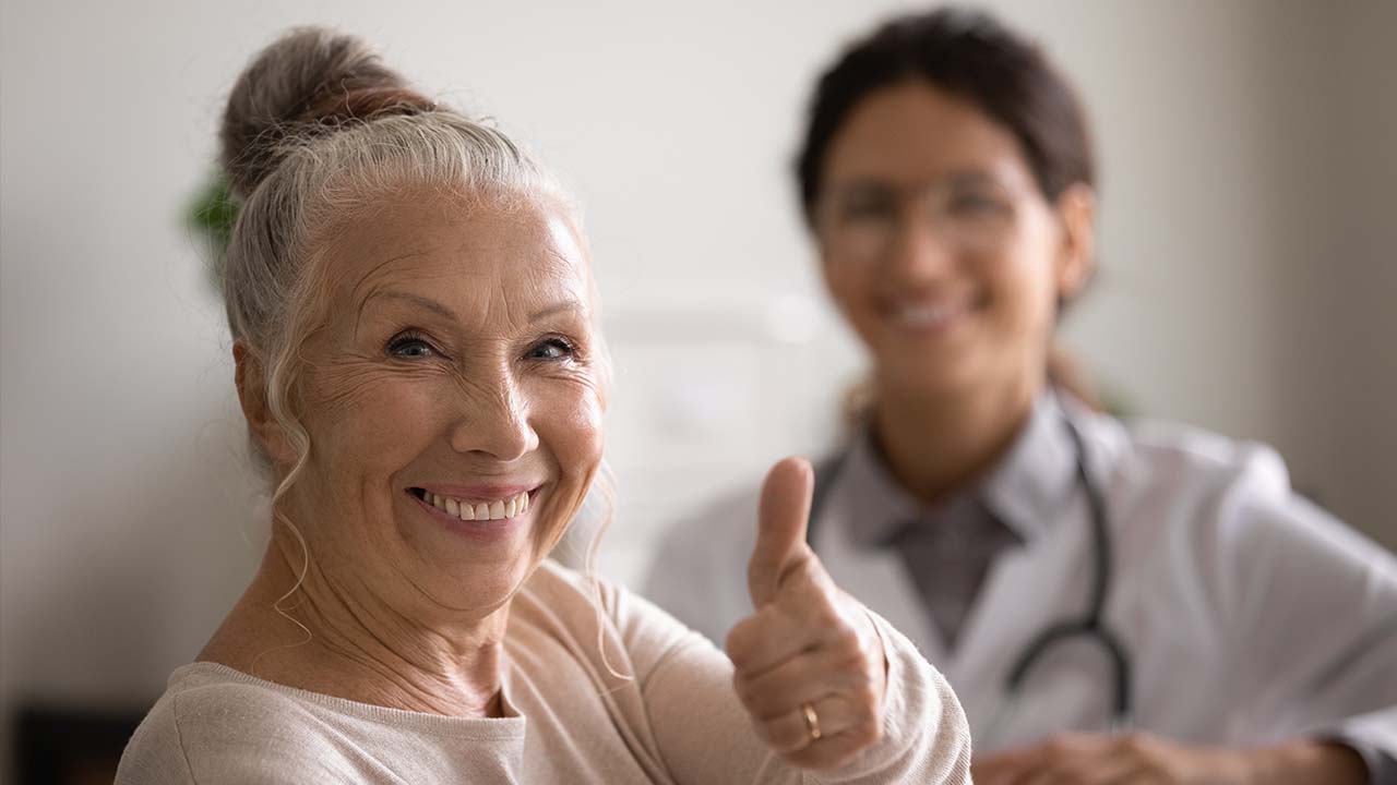 woman sitting nest to a doctor with a thumbs up
